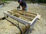 Applying construction cement to the coop floor joists