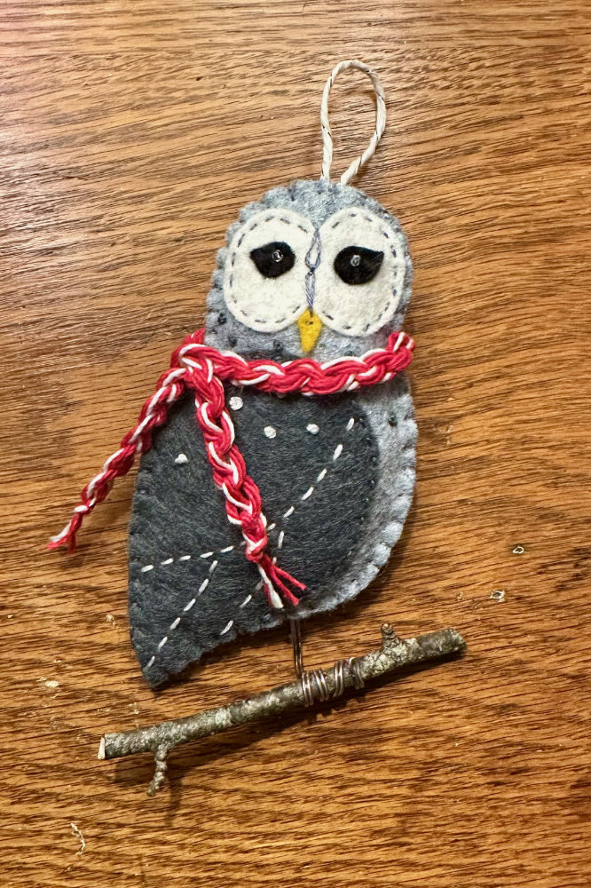 felt joyful owl ornament with a scarf perched on a twig