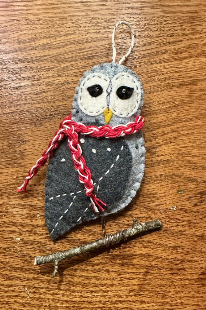 felt joyful owl ornament with a scarf perched on a twig